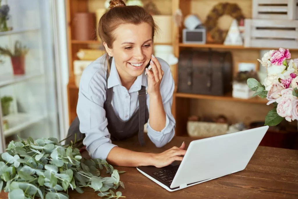 A self-employed woman working on her laptop at a table.