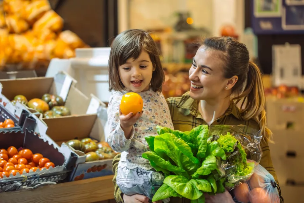 A young woman and her child buying some healthy food at the supermarket thanks to the Healthy Start card.